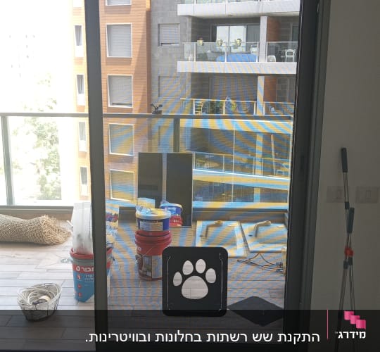 דלת אלומיניום עם רשת וכלי עבודה על הרצפה